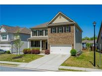 Traditional two-story home featuring brick facade, attached garage and manicured lawn at 2649 Ogden Trl, Buford, GA 30519
