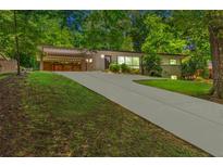 Charming single-story home with a long driveway and well-maintained lawn at 1492 Sagewood Cir, Stone Mountain, GA 30083