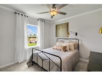 Cozy bedroom featuring a black metal bed frame, soft neutral bedding, and ample natural light from a window at 710 Pineberry Ct, Grayson, GA 30017