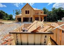 New home under construction with exposed framework and large dumpster in the foreground on a sunny day at 723 Crest Line Trl, Powder Springs, GA 30127
