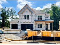 New construction home featuring a two-car garage, covered entry, and Kingspan GreenGuard weather barrier at 723 Crest Line Trl, Powder Springs, GA 30127