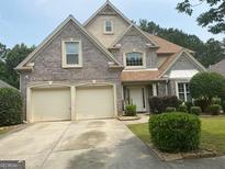 Charming two-story home with brick facade, well-manicured landscaping and an attached two-car garage at 7981 Gossamer Dr, Fairburn, GA 30213