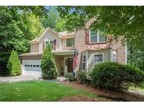 Charming two-story home featuring a well-manicured lawn, a two-car garage, and a welcoming front porch at 1625 Rushing River Way, Suwanee, GA 30024