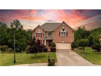 Charming two-story brick home with lush landscaping and a spacious driveway leading to a two-car garage at 638 Glen Valley Way, Dacula, GA 30019