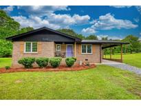 Charming brick home with a well-maintained lawn and a welcoming purple front door at 370 Walnut St, Social Circle, GA 30025