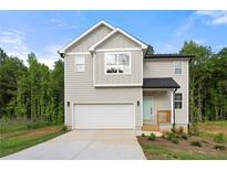 Charming two-story home with a two-car garage, light siding, and landscaped front yard at 4095 Oriole Ln, Fairburn, GA 30213