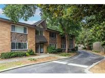 Exterior shot of the apartment building with brick and stone accents, lush landscaping, and an inviting entrance at 115 Biscayne Nw Dr # F10, Atlanta, GA 30309