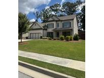 Beautiful two-story home with a well-maintained lawn and attached three-car garage at 2159 Holland Creek Ln, Buford, GA 30519