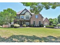 Beautiful two-story brick home with a well-manicured lawn and lush landscaping at 3487 Binghurst Rd, Suwanee, GA 30024