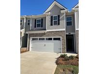 Two story home featuring a large two car garage and shingle siding at 1402 Grand Branch Dr, Lawrenceville, GA 30045