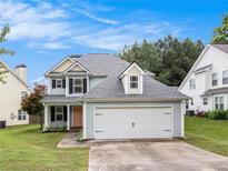Charming two-story home with a two-car garage and manicured lawn at 161 Brasch Park Dr, Grantville, GA 30220