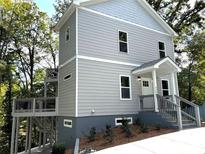 Charming two-story home featuring a modern exterior, multilevel deck, landscaped yard, and inviting entrance at 2125 Clay Rd, Austell, GA 30106