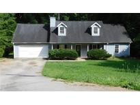 Charming single-story home with blue siding, dormer windows, a 2-car garage, and a well-maintained front yard at 330 Christian Woods Dr, Conyers, GA 30013