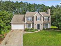 Charming two-story home features a manicured lawn, attached garage, and classic architectural details at 405 Mount Vernon Ct, Woodstock, GA 30189
