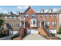 Brick townhome with attached garages, symmetrical window placement, and well-maintained landscaping at 6043 China Rose Lane, Johns Creek, GA 30097