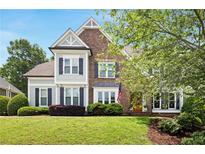 Charming two-story home featuring a brick facade, light blue accents, and a well-manicured lawn at 113 Stargaze Rdg, Canton, GA 30114