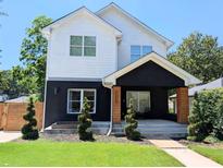 Charming two-story home with a modern black and white exterior, complemented by a well-manicured front yard at 123 Dahlgren St, Atlanta, GA 30317