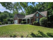 Charming brick home with lush front yard and attached two-car garage in a tree-lined neighborhood at 2063 Willow Chase Ct, Tucker, GA 30084