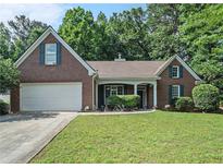Charming brick home featuring a well-manicured lawn, attached garage, and inviting front porch at 2063 Willow Chase Ct, Tucker, GA 30084