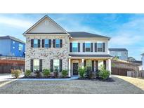 Inviting two-story home featuring a brick and siding exterior with a well-manicured front yard at 4825 Odum View Ln, Cumming, GA 30040