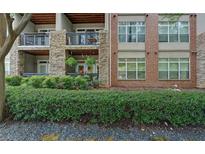 Stylish condo exterior featuring stone and brick accents, balconies, and lush landscaping at 840 United Ave # 113, Atlanta, GA 30312