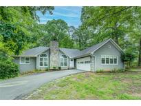 Charming home with a stone chimney, arched windows, and a convenient attached garage at 2690 Ross Rd, Snellville, GA 30039
