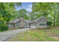 Charming single-story home featuring stone accents, a side entry garage and a beautifully landscaped yard at 2690 Ross Rd, Snellville, GA 30039
