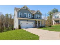 Charming two-story home with light blue siding, white trim, and a well-manicured lawn at 109 Laurelwood Ln, Dallas, GA 30157