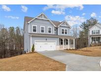 Charming two-story home with a two-car garage, covered front porch, and blue siding at 109 Laurelwood Ln, Dallas, GA 30157