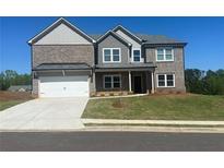 Beautiful two story home with gray brick and gray siding, professionally landscaped lawn and two car garage at 57 Longhorn Way, Auburn, GA 30011