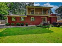 Charming brick two-story home with a well-manicured lawn and a cozy second story balcony at 1177 Castle Way Way, Norcross, GA 30093