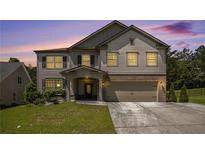 Charming two-story home with a brick-accented facade and well-manicured front lawn at dusk at 3005 Nicholas Dr, Villa Rica, GA 30180