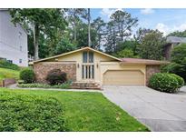 Charming single Gathering home with stone accents, well-manicured lawn and two-car garage at 3272 Pinestream Nw Rd, Atlanta, GA 30327