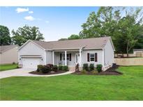 Charming home with a well-manicured lawn, gray siding, and a cozy front porch at 521 Peeples Valley Nw Rd, Cartersville, GA 30121