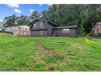Charming home featuring a brick facade, lovely landscaping, and a well-maintained lawn at 1239 Teakwood Trl, Stone Mountain, GA 30083