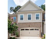 Attractive brick and siding exterior with a two-car garage and manicured landscaping at 203 Holden Way, Woodstock, GA 30189