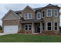 Charming two-story brick home with a well-manicured lawn and attached two-car garage at 596 Rodeo Dr, Auburn, GA 30011