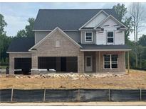 Two-story home featuring a gray color scheme, brick accents, an attached two car garage, and a dark roof at 5220 Birch Valley Rd, Cumming, GA 30028