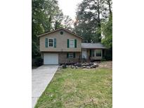 Charming split-level home featuring green shutters, brick accents, and an attached garage at 539 Rue Montaigne, Stone Mountain, GA 30083