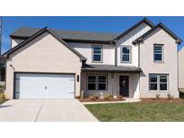 Charming two-story home with a brick facade, attached garage, and professionally landscaped front yard at 606 Rodeo Dr, Auburn, GA 30011