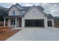 Charming two-story home with light brick, a large driveway and a two-car garage at 5245 Birch Valley Rd, Cumming, GA 30028