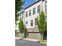 Modern townhome showcasing white brick, gray trim, garage, and manicured trees at 215 Arizona Ne Ave # 3, Atlanta, GA 30307