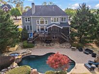 Stunning backyard pool and spa with lush landscaping and outdoor living space at 410 Hickory Fairway Ct, Woodstock, GA 30188