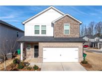 Charming two-story home with a brick and stone facade and a two-car garage at 4798 Red Lion Pl, Lawrenceville, GA 30044