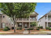 Charming two-story home with a front porch and balcony overlooking a well-maintained, beautifully landscaped front yard at 559 Myrle Trace Ln, Suwanee, GA 30024