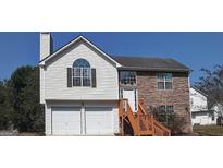Charming two-story home featuring a stone facade, two-car garage, and well-maintained landscaping at 7101 Brecken Pl, Lithonia, GA 30058