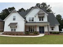 Charming two-story home featuring board and batten siding, stone accents, and a well-manicured lawn at 72 Hanover Dr, Villa Rica, GA 30180