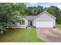 Charming single-Gathering home featuring a two-car garage, stone accents, and well-maintained landscaping at 784 Crestworth Xing, Powder Springs, GA 30127