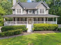 Charming two-story home featuring a welcoming front porch, well-manicured lawn, and lush landscaping at 150 Kensley Way, Dallas, GA 30157