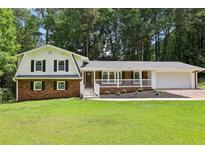 Charming two-story home with brick accents, white siding, and a welcoming covered front porch at 6000 Malibu Drive Dr, Morrow, GA 30260